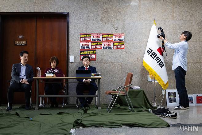 권성동 국민의힘 원내대표(가운데)가 5월8일 오전 원내대표실 앞에서 단식 농성을 하며 영상을 시청하고 있다(왼쪽부터 농성장을 방문한 최은석 원내대표 비서실장, 단식농성에 동참한 김미애 의원). ⓒ시사IN 신선영