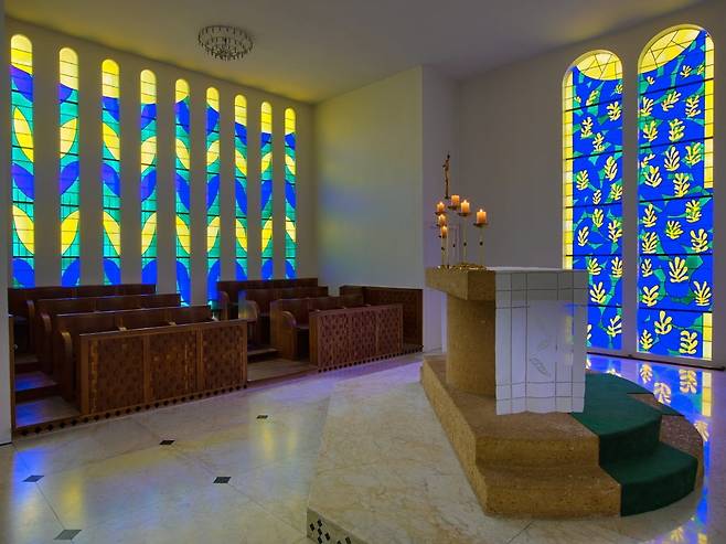 앙리 마티스가 장식한 로사리오 성당 내부. 마티스는 성당 내부의 스테인드글라스 창과 벽화 디자인을 총괄했다. 그는 종이 오리기 기법으로 창문의 초안들을 만들어 색유리 배치를 결정했고, 성모자와 성 도미니크 등의 벽화도 직접 그렸다. 1951년 봉헌된 이 작은 성당은 마티스의 말년 영혼을 쏟은 걸작으로 불린다. 흰 벽과 선명한 색유리가 이루는 단순하면서 경건한 공간은 그가 평생 추구한 '균형과 평온'의 예술을 종교적 맥락에서 완성했다는 평가다. 마티스 자신도 색채와 빛이 어우러진 이 공간에 깊이 만족했다. "그것은 나의 모든 것이다... 어린 시절 나에게 좋았던 모든 것이다." © Succession H. Matisse  Photo © François Fernandez