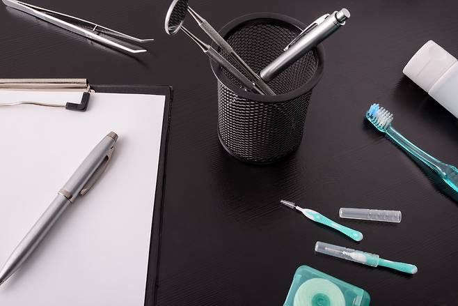 An office desk with grooming tools including a toothbrush and dental flosses. [GETTY IMAGES]