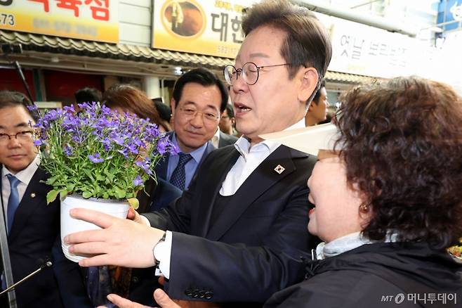 [함안=뉴시스] 조성우 기자 = 민심을 청취하는 '경청 투어'에 나선 이재명 더불어민주당 대선후보가 10일 경남 함안군 가야시장에서 화분을 보고 있다. 2025.05.10. xconfind@newsis.com /사진=조성우