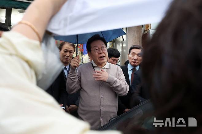 [고령=뉴시스] 조성우 기자 = 민심을 청취하는 '경청 투어'에 나선 이재명 더불어민주당 대선후보가 지난 9일 경북 고령군 대가야역사공원 인근에서 민원을 제기하는 한 시민과 대화하고 있다. 2025.05.09. xconfind@newsis.com