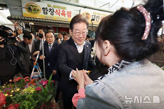 [함안=뉴시스] 조성우 기자 = 민심을 청취하는 '경청 투어'에 나선 이재명 더불어민주당 대선후보가 10일 경남 함안군 가야시장 다육가게 상인과 인사하고 있다. 2025.05.10. xconfind@newsis.com