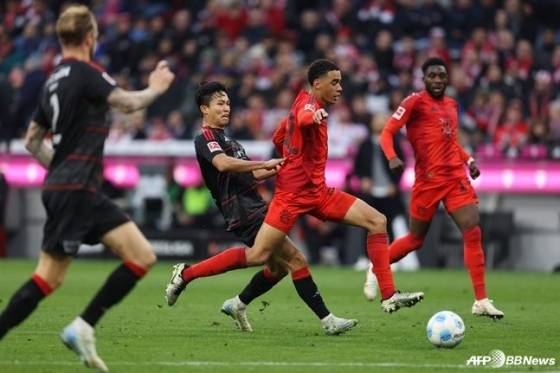 정우영(가운데)이 독일 뮌헨의 알리안츠 아레나에서 열린 2024~2025시즌 독일 분데스리가 9라운드 경기 중 자말 무시알라를 막아서고 있다. /AFPBBNews=뉴스1