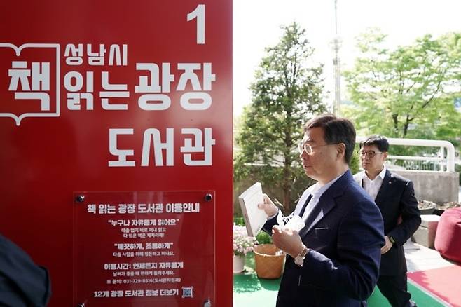 ▲ 신상진 성남시장이 지난 4월 26일 열린 중원유스센터 광장의 '책 읽는 광장 도서관' 개관식에서 책을 읽고 보관함에 넣고 있다. /사진제공=성남시