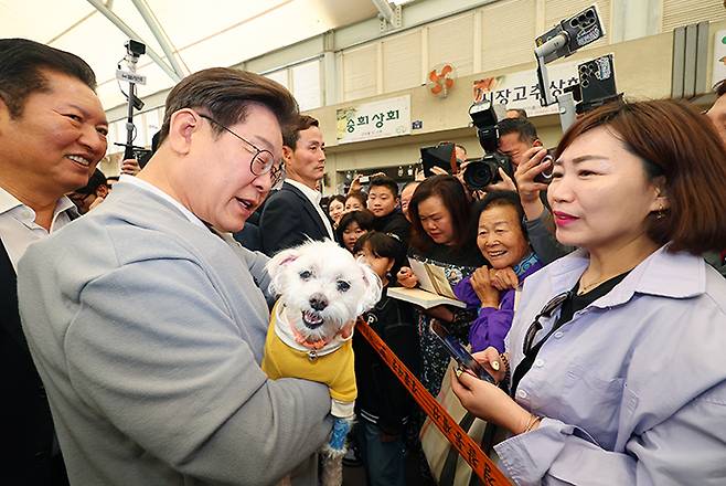 남도문화벨트 골목골목 경청투어에 나선 더불어민주당 이재명 대선 후보가 11일 전남 강진군 강진읍 강진오감통시장을 찾아 한 지지자의 반려견을 품에 안고 인사를 하고 있다. 연합뉴스