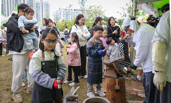 제21회 울산쇠부리축제가 열리고 있는 지난 10일 달천철장을 찾은 아이들이 직접 달궈진 쇠를 두드려 가며 호미를 만드는 체험을 하고 있다. 이수화 기자