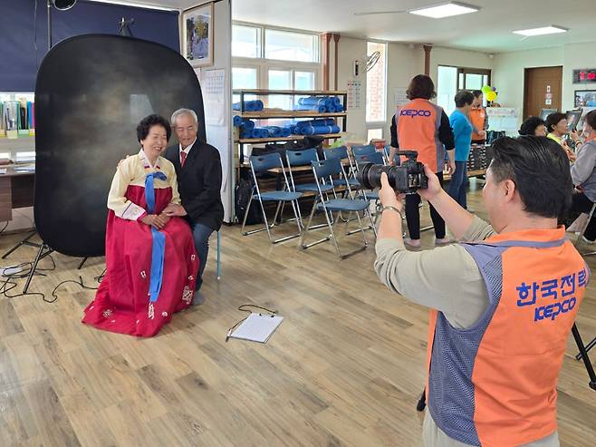 작년 4월 한국전력 직원이 강원도 홍천군의 한 마을회관에서 부부의 사진을 찍고 있다. 한국전력은 가족 사진 촬영, 농번기 일손 돕기 등을 통해 송전탑이 들어서는 지역 주민들과 적극 소통하려 했다고 한다./한국전력