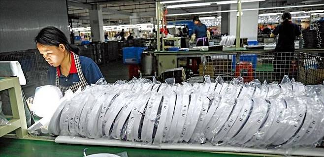 중국 남부 광둥성 중산시에 있는 발광다이오드(LED) 조명 업체의 조립 라인에서 한 여성 직원이 일하고 있다. ⓒ AFP/연합뉴스