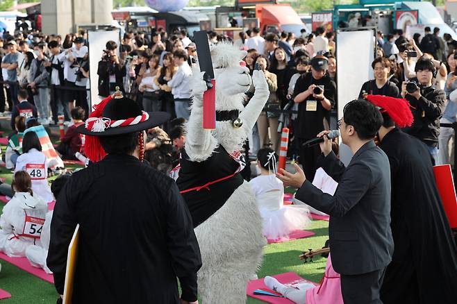 2025 한강 멍때리기 대회 참가자 중 라마 인형 탈을 쓴 최초 탈락자가 11일 서울 서초구 반포한강공원 잠수교에서 시민에게 인사하고 있다. 김영원 기자 forever@hani.co.kr