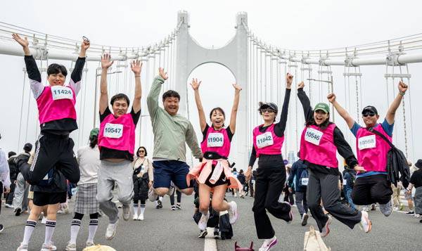 광안대교서 잊지 못할 추억- 11일 2025 다이아몬드브리지 국제걷기축제 참가자들이 광안대교 상판 위에서 힘차게 뛰어오르고 있다.