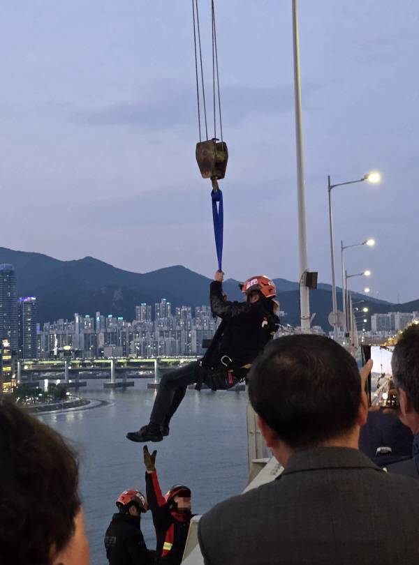 11일 오후 7시30분 부산 광안대교 상판에서 고공 농성을 벌이던 형제복지원 피해 생존자 최승우(57) 씨가 8시간 만에 다리에서 내려왔다. 사진은 소방 크레인에 의해 구조되는 모습. 덕성원 피해생존자협의회 제공