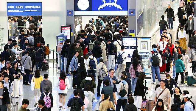 해외 결제 시장점유율을 확대하기 위한 카드사 간 경쟁이 치열하다. 사진은 지난 5월 1일부터 엿새간 이어지는 황금연휴를 앞둔 4월 30일 인천국제공항 제1여객터미널 출국장에서 승객들이 탑승 수속을 위해 줄을 길게 늘어선 모습. (연합뉴스)