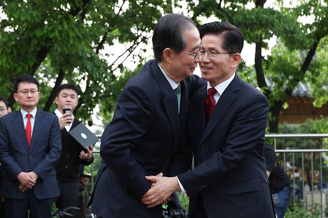 김문수(오른쪽) 국민의힘 대선후보와 한덕수(왼쪽) 무소속 대선 예비후보가 8일 서울 국회 사랑재에 위치한 커피숍에서 회동을 마친 후 포옹하고 있다. [연합]