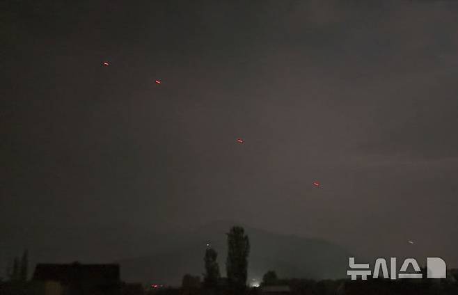 [스리나가르=AP/뉴시스] 인도와 파키스탄이 휴전에 합의한 10일(현지 시간) 인도 통제 지역인 카슈미르 스리나가르 상공에 붉은 물체가 비행 중이다. 휴전 발표 몇 시간 만에 양측 국경에서 폭발음이 들리면서 확전 우려가 다시 커지고 있다. 2025.05.11.