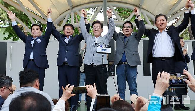 [해남=뉴시스] 조성우 기자 = 민심을 청취하는 '경청 투어'에 나선 이재명 더불어민주당 대선후보가 11일 전남 해남군 해남읍 인근 광장에서 연설을 마친 뒤 박지원, 서삼석, 정청래 의원의 등과 손을 맞잡고 주민들에게 인사하고 있다. 2025.05.11. xconfind@newsis.com