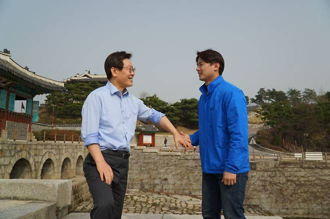 지난 2018년 지방선거 예비후보 시절 이재명 후보가 청소년 시절 공장일을 하다 다쳐 굽은 팔로 황대호 위원장 손을 잡고 있는 모습. 황 위원장 측 제공