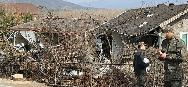 ▲ 지난 3월 12일 군 관계자들이 오폭지점 인근에 무너져 내린 민가 앞을 지나고 있다. /김철빈 기자 narodo@incheonilbo.com