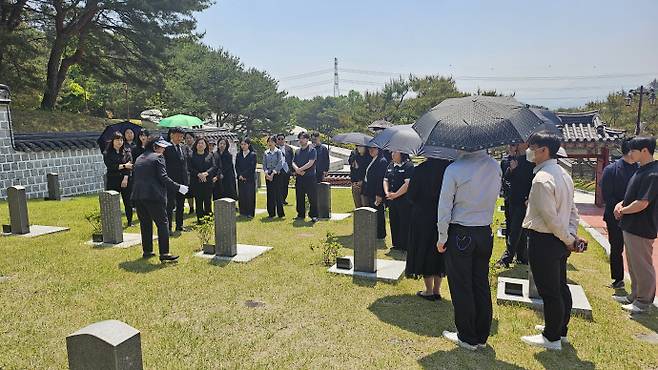 12일 오전 국립 5·18민주묘지를 방문한 광주기후에너지진흥원 임직원들이 묘비 앞에서 해설사의 설명을 듣고 있다. /박준호 기자 bjh@namdonews.com