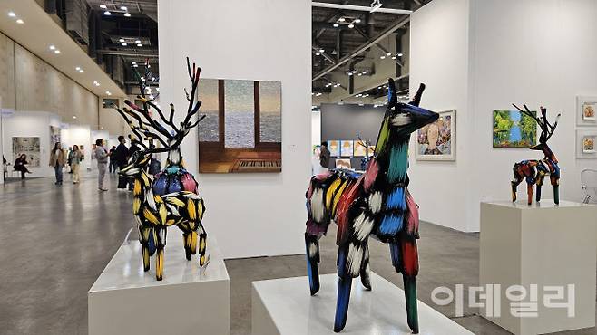 ‘아트부산 2025’ 소울아트스페이스 전경. 김우진 작가의 조각작품 ‘말’(2025), ‘사슴’(2025) 등이 화려한 색감과 단단한 자태로 시선을 끌었다. 뒤쪽으로 김덕용 작가의 ‘관해음’(2024)이 보인다(사진=오현주 문화전문기자).
