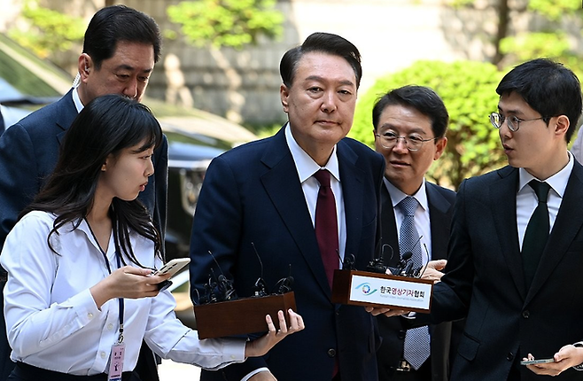 윤석열 전 대통령이 12일 서울 서초구 중앙지방법원에서 열린 내란 우두머리 혐의, 직권남용 권리행사방해 혐의 사건 3차 공판에 출석, 취재진의 질문을 받으며 이동하고 있다.ⓒ연합뉴스