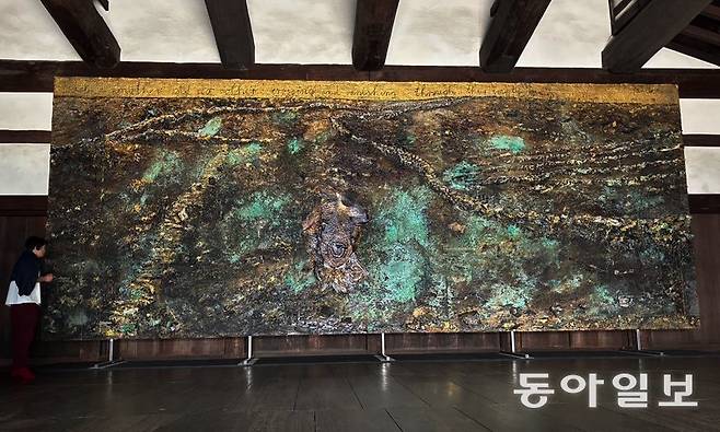 일본 교토 니조성에 설치된 안젤름 키퍼의 대작 회화 ‘옥타비오 파스를 위하여’. 키퍼가 이번 개인전을 위해 지난해 여름 완성한 작품이다. 폭 9m가 넘는 캔버스에 금박과 금속을 산화한 청록색 안료 및 돌과 숯 등을 사용해 들판을 그렸다. 그림 위엔 ‘각자는 서로이며 그 누구도 아니다: 텅 빈 이름 사이로 서로 스치고 사라질 뿐’이라는 파스의 시 ‘바람, 물, 돌’의 마지막 구절이 적혀 있다. 교토=김민 기자 kimmin@donga.com