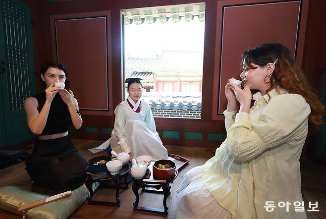12일 서울 종로구 창덕궁 약방에서 열린 2025년 창덕궁 약다방 사전 행사에서 외국인들이 전통다과와 한방차를 시식하고 있다. 송은석 기자 silverstone@donga.com