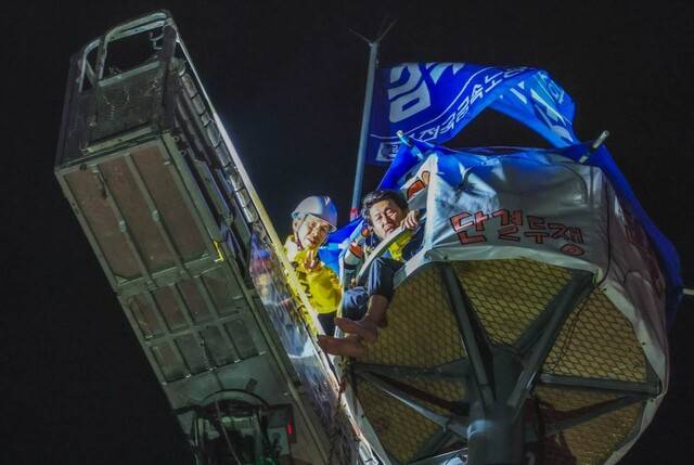 권영국 민주노동당 대통령 후보가 12일 새벽 서울 중구 한화빌딩 앞에서 고공농성하고 있는 김형수 전국금속노조 거제·통영·고성 조선하청지회장과 만난 모습. 민주노동당 제공