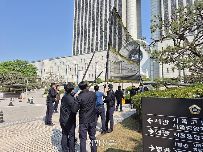 경찰 관계자들이 12일 오전 서울 서초구 법원 청사 앞에서 투척물 방지용 그물망을 펴 보이고 있다. 김태욱 기자