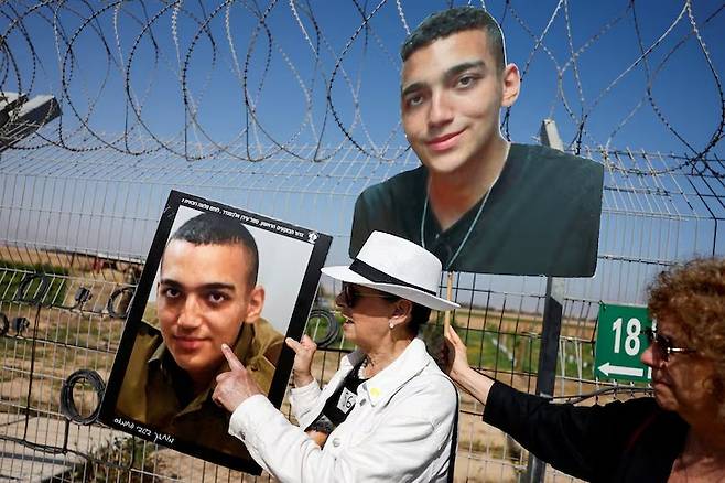 하마스에 붙잡혀 인질이 된 에단 알렉산더의 사진을 가리키는 조모 바르다 벤 베어럭/로이터=뉴스1