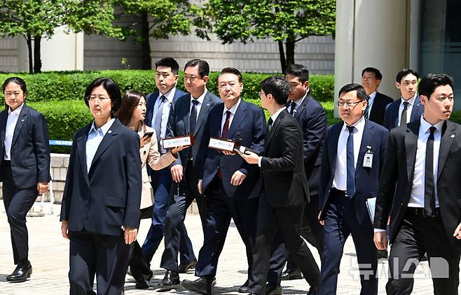 [서울=뉴시스] 사진공동취재단 = 12·3 비상계엄 사태와 관련해 내란 우두머리 혐의 등으로 기소된 윤석열 전 대통령이 12일 서울 서초구 서울중앙지방법원에서 열린 3차 공판에서 오전 공판을 마치고 법원을 나서고 있다. 2025.05.12. photo@newsis.com
