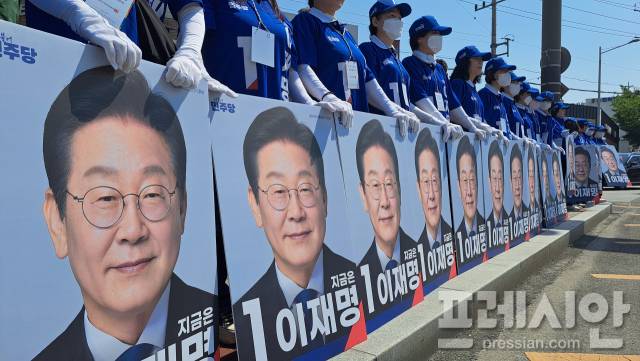 ▲12일 전남 순천시 아랫장에서 열린 '민주당 전남도당 대선 선거운동 출정식'에 참석한 선거운동원들이 이재명 민주당 대통령 후보 사진을 들고 서 있다.ⓒ프레시안(지정운)