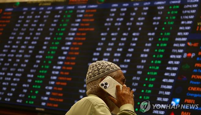 파키스탄 증권거래소 (카라치 EPA=연합뉴스) 12일 파키스탄 카라치에서 한 투자자가 주식 시세 전광판 앞에서 통화하고 있다. 2025.5.12. photo@yna.co.kr