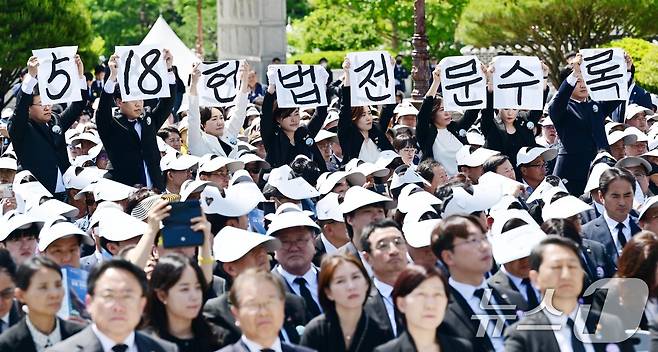 윤석열 대통령이 18일 광주 북구 국립5·18민주묘지에서 열린 5·18민주화운동 제44주년 기념식에서 기념사를 하는 가운데 광주시의회 5·18특별위원회 위원들이 '5·18 헌법 전문 수록'이라고 적힌 손팻말을 들고 있다. (공동취재) 2024.5.18/뉴스1 ⓒ News1 안은나 기자