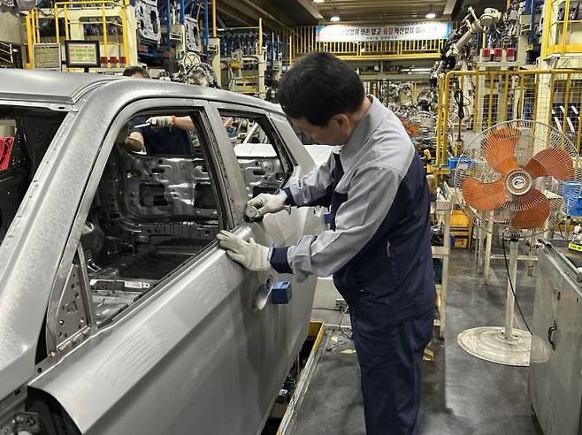 지난해 말 정년퇴직 후 재고용 된 황주원씨가 2일 KG모빌리티 평택 공장 차체품질라인에서 차체를 점검하고 있다.