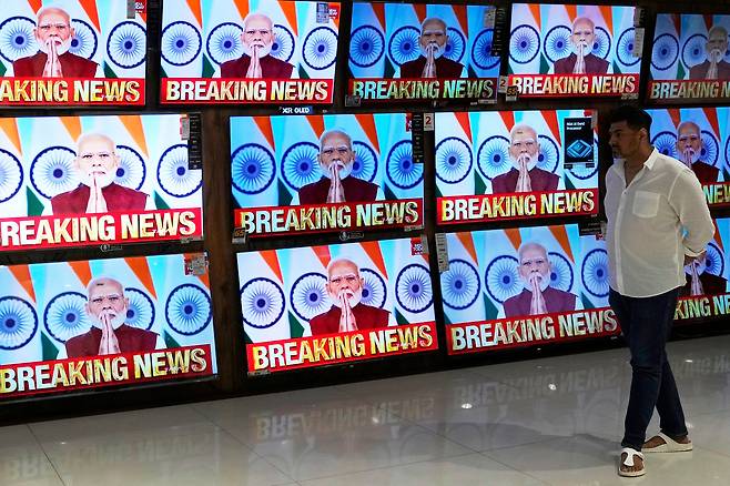 12일(현지시각) 인도 뭄바이의 한 쇼핑몰에서 인도 시민이 나렌드라 모디 총리의 연설을 텔레비전 화면으로 지켜보고 있다. /AP·연합뉴스