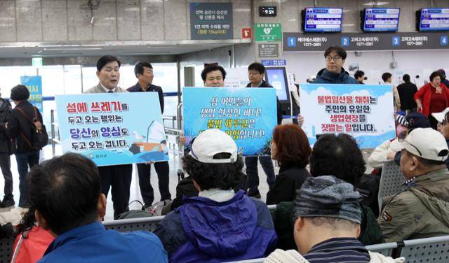 문경복(왼쪽 첫 번째) 옹진군수 등 인천 옹진군 관계자들이 2일 인천항 연안여객터미널에서 '쓰레기 되가져가기' '불법 해루질 근절' 등을 섬 관광객들에게 요청하고 있다. 옹진군 제공