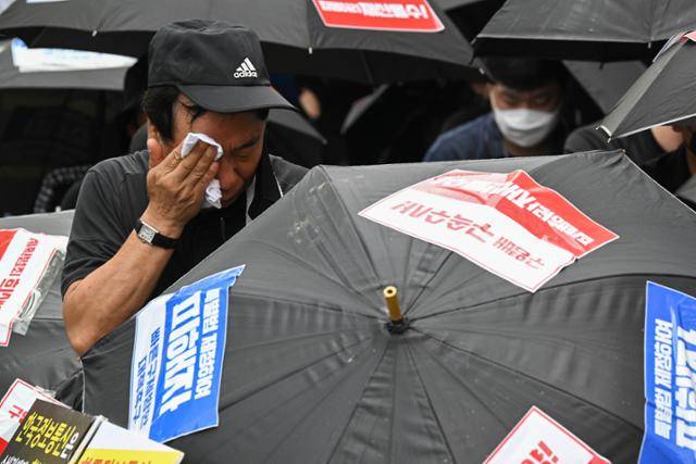 '티메프(티몬·위메프) 사태'의 한 피해자가 지난해 8월 13일 서울 강남구 티몬 사옥 앞에서 조속한 정산 및 환불, 구영배 큐텐 회장 수사를 촉구하는 검은 우산 집회 도중 눈물을 흘리고 있다. 신용주 인턴기자