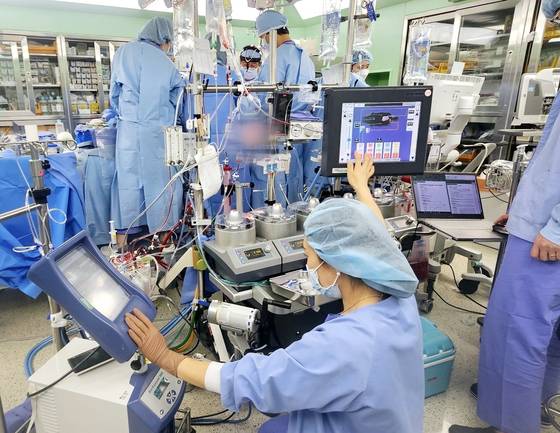 오지영 체외순환사가 인공심폐기 등을 조작하고 있다. 1~2m 이내에서 정 교수가 심장 수술을 집도하고 있다. 채혜선 기자