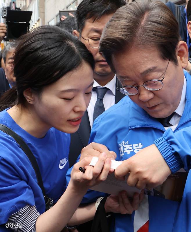 시민 책에 저자 사인 이재명 더불어민주당 대선 후보가 13일 대구 동성로에서 열린 집중유세를 마친 뒤 한 시민의 요청에 자신의 저서에 사인을 하고 있다. 박민규 선임기자 parkyu@kyunghyang.com
