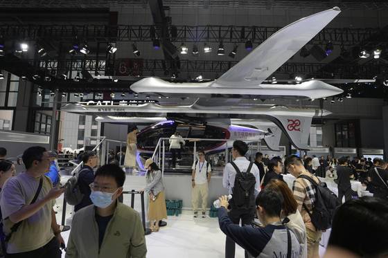 Visitors stand near a flying test platform from Chinese battery manufacturer CATL during the Shanghai auto show on April 23, 2025. [AP/YONHAP]