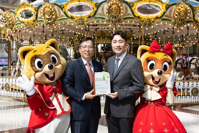롯데월드 어드벤처가 레저 업계 최초로 8회 연속 실내공기질 인증을 획득했다. 인증서를 들고 기념촬영을 하고 있는 김기훈 롯데월드 영업본부장(오른쪽)과 김태형 한국표준협회 인증본부장(왼쪽) / 사진=롯데월드 어드벤처