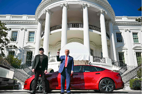 i도널드 트럼프 미국 대통령이 붉은색 테슬라 모델S 차량 앞에서 일론 머스크 테슬라 최고경영자(CEO)와 나란히 서서 “8만달러에 판매되는 이 차량을 구입했다”고 말했다. (사진=AFP연합)