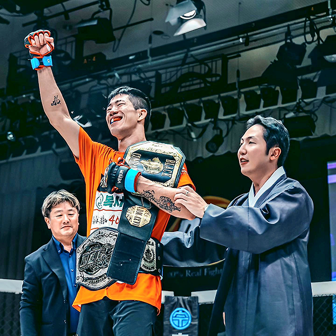 이송하가 2023년 9월 일본 도쿄 고라쿠엔홀에서 제2대 블랙컴뱃 라이트급 챔피언 타이틀 2차 방어 성공 및 제11대 DEEP 라이트급 챔피언 등극 후 기뻐하고 있다. 왼쪽은 사에키 시게루 DEEP 대표, 오른쪽은 박평화 블랙컴뱃 대표. 사진=이데아 파라곤