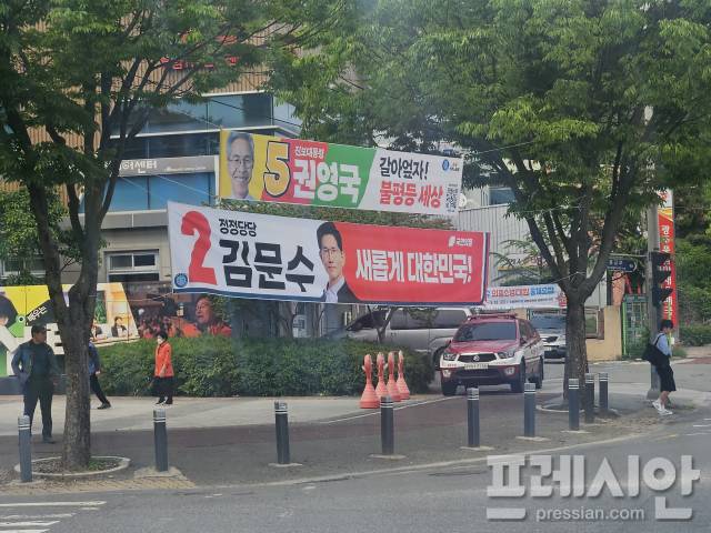 ▲13일 광주 서구 사거리 문제가 된 이준석 개혁신당 대선후보 현수막 건너편에 설치된 타 대선 후보 현수막들. 시민들의 통행하기에 불편함 없는 높이가 확보된 모습이다.2025.5.13ⓒ프레시안(김보현)