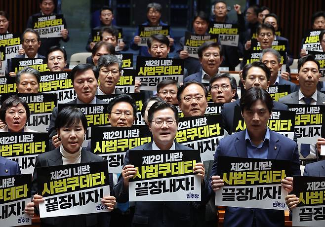 박찬대 더불어민주당 원내대표를 비롯한 의원들이 5월4일 국회에서 열린 긴급 의원총회에서 대법원 규탄 팻말을 들고 구호를 외치고 있다. ⓒ 연합뉴스