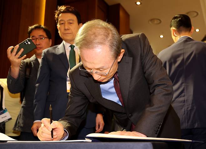 첫날인 14일 오전 열린 개막식에 참석한 이명박 전 대통령이 방명록을 적고 있다.