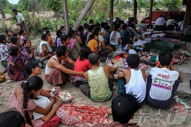 12일(현지시간) 미얀마 사가잉 지역 데파인타운십의 오헤 테인 트윈 마을에서 미얀마군의 폭격으로 사망한 희쟁자들의 장례식에서 유가족을 비롯한 참석자들이 애도하고 있다. ⓒ AFP=뉴스1