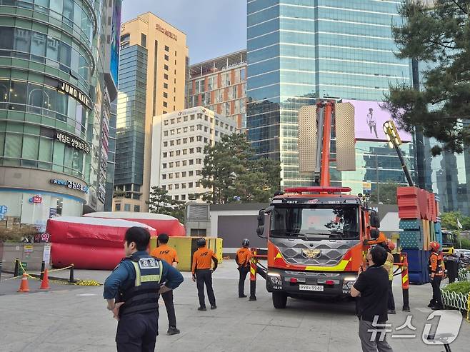 지난 13일 오후 3시쯤 서울 지하철 강남역 11번 출구 인근 한 고층 빌딩에 한 남성이 서있다는 신고가 접수돼 소방이 에어매트를 까는 등 구조작업에 착수하고, 경찰이 주변 통행을 통제하고 있는 모습. ⓒ 뉴스1 남해인 기자