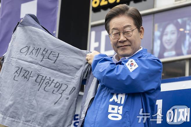 이재명 더불어민주당 대통령 후보가 민주당 험지로 꼽히는 부산·경남(PK) 지역 유세에 나선 14일 경남 창원시 상남분수광장에서 열린 집중유세에서 송순호 경남도당위원장으로부터 '이제부터 진짜 대한민국!' 문구가 써진 작업복을 전달 받고 있다. (공동취재) 2025.5.14/뉴스1 ⓒ News1 안은나 기자