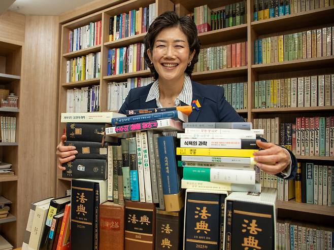 조미현 대표가 현암사의 역사를 보여주는 책들을 껴안고 있다. 해방 후 첫 우리글로 만든 법전부터 1963년 29세였던 이어령이 쓴 ‘흙 속에 저 바람 속에’, 소설가 황석영이 1970년대 쓴 장길산 초판 등이다. /조인원 기자